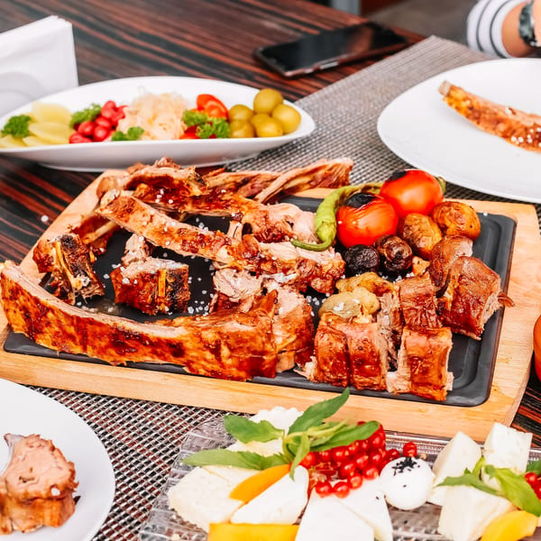 Platter of Bear West BBQ ribs, grilled vegetables, and a side of cheese and fruit.